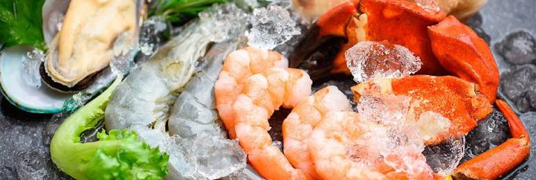 Variedad de mariscos frescos y congelados sobre hielo